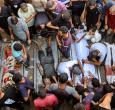 La gente rodea los cadáveres de palestinos, algunos muertos en los ataques israelíes de madrugada y otros asesinados el día anterior mientras buscaban ayuda humanitaria cerca de Zikim, al oeste de Beit Lahia, en el patio del hospital al-Shifa de la ciudad de Gaza.