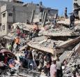 Palestinos inspeccionan un edificio destruido tras el bombardeo nocturno del ejército israelí sobre el campo de refugiados palestinos de Al-Shati, al oeste de la ciudad de Gaza.