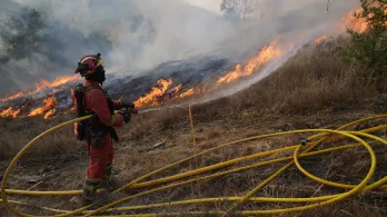Un miembro de la Unidad Militar de Emergencias (UME) de España combate un incendio forestal en Garano, al noroeste de España.