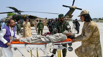 Voluntarios afganos y personal de seguridad talibán transportan a una víctima del terremoto evacuada por un helicóptero militar desde el distrito de Nurgal, en la provincia de Kunar, tras su llegada a Jalalabad para recibir asistencia médica.