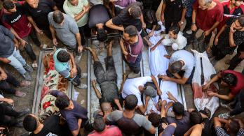 La gente rodea los cadáveres de palestinos, algunos muertos en los ataques israelíes de madrugada y otros asesinados el día anterior mientras buscaban ayuda humanitaria cerca de Zikim, al oeste de Beit Lahia, en el patio del hospital al-Shifa de la ciudad de Gaza.