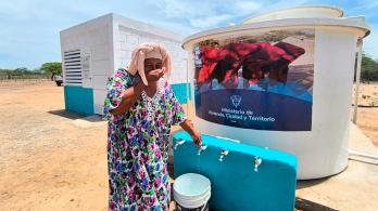 Mujer de la comunidad de Manaure utilizando el sistema de agua potable entregado por el Ministerio de Vivienda