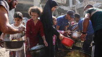 Los palestinos desplazados de Gaza se reúnen para recibir raciones de comida frente a la mezquita Imam al Shafi'i, dañada, donde se han refugiado familias, en el barrio de Zeitoun de la ciudad de Gaza.