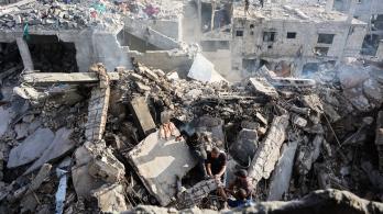 Palestinos intentan recuperar un cadáver de entre los escombros de una casa destruida en un ataque israelí durante la noche, en la ciudad de Gaza.