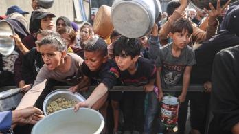 Jóvenes palestinos desplazados esperan con sus recipientes para recibir una ración de comida en el campo de refugiados de Nuseirat, en el centro de la Franja de Gaza, tras hambruna declarada por la ONU en el enclave. 