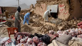 Los comerciantes de Afganistán buscan los restos de sus tiendas dañadas a lo largo de una carretera, tras un terremoto en Tang-e Tashkurgan, en el distrito de Khulm, provincia de Samangan.