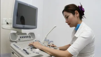 persona del sector salud operando una máquina de ecografías