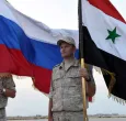 Soldados con la bandera de Siria y Rusia