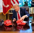 El presidente Donald Trump acomoda sus gorritas con el lema "Make America Great Again"