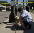 Persona dejando florez en el lugar del tiroteo en minneapolis