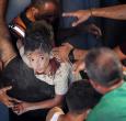 Palestinos transportan a un niño herido en el lugar donde se produjo un ataque israelí que destruyó varios edificios en el barrio de Al-Rimal, en la ciudad de Gaza.