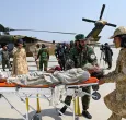 Voluntarios afganos y personal de seguridad talibán transportan a una víctima del terremoto evacuada por un helicóptero militar desde el distrito de Nurgal, en la provincia de Kunar, tras su llegada a Jalalabad para recibir asistencia médica.