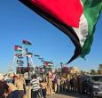 Personas posan para una foto frente al barco Omar al-Mukhtar, un barco libio que zarpó el 17 de septiembre para unirse a la Flotilla Global Sumud, en el puerto de Trípoli. 
