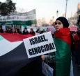 Una mujer sostiene un cartel con el lema «¡Israel, genocidio!» durante una manifestación en apoyo al pueblo palestino y para exigir el fin de la guerra en Gaza, celebrada en Madrid.