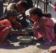 En un comedor social de Jan Yunis, en el sur de la Franja de Gaza, se reparten raciones de comida caliente entre los niños palestinos. Mientras esperan su turno, algunos comen arroz cocido.
