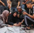 Los palestinos lloran junto al cadáver de un familiar asesinado en los ataques israelíes contra la ciudad de Gaza al amanecer, en el hospital Al-Shifa. 