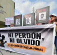 Familiares y miembros de organizaciones de derechos humanos sostienen fotografías y una pancarta con el lema «Ni perdón ni olvido» frente a un tribunal de Guayaquil, Ecuador, tras la condena de los 11 militares por desaparición forzada. 