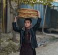 Un niño en Afganistán lleva panes por una calle del distrito de Fayzabad, en la provincia de Badakhshan.
