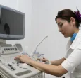 persona del sector salud operando una máquina de ecografías