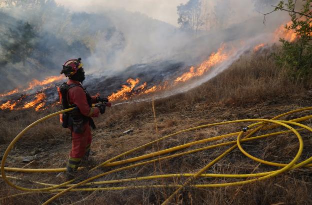 Un miembro de la Unidad Militar de Emergencias (UME) de España combate un incendio forestal en Garano, al noroeste de España.