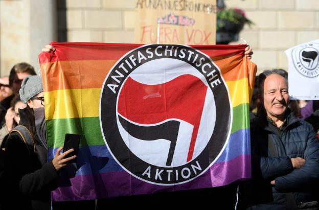 Contramanifestantes sostienen una bandera del partido antifascista Aktion en Barcelona el 12 de enero de 2020 durante una concentración de simpatizantes del partido español de extrema derecha VOX para protestar contra el nuevo gobierno de coalición del presidente del Gobierno español.