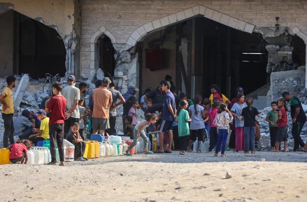 Los palestinos desplazados por el conflicto hacen cola para recoger agua en el complejo residencial Hamad City, construido por Catar, en el noroeste de Jan Yunis, en el sur de la Franja de Gaza.