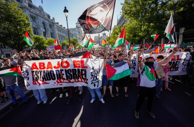 Manifestantes pro palestinos enarbolan banderas y pancartas palestinas tras invadir la calle y obligar a los organizadores de la carrera a suspender la 21.ª y última etapa de la Vuelta a España 2025, una carrera de 101 km entre Alalpardo y Madrid, en Madrid.