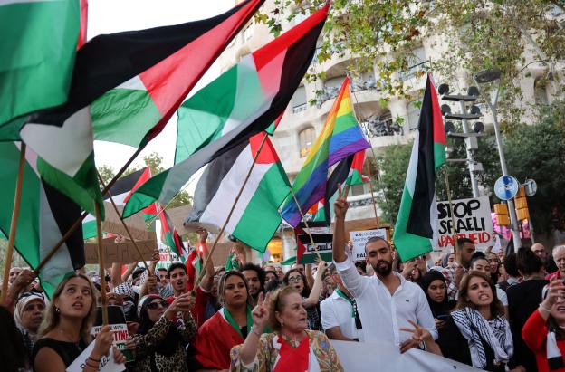 Manifestantes hacen gestos y ondean banderas palestinas durante una concentración convocada por la «Comunitat Palestina de Catalunya» (Comunidad Palestina de Cataluña) en solidaridad con los palestinos, frente al edificio «Casa Milà» del arquitecto español Antonio Gaudí, conocido popularmente como «La Pedrera», en Barcelona.