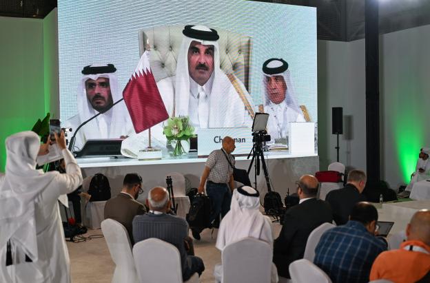 Los periodistas siguen el discurso del emir de Catar, el jeque Tamim bin Hamad Al-Thani, en el centro de prensa, durante la inauguración de la cumbre árabe-islámica de emergencia de 2025 en Doha. 