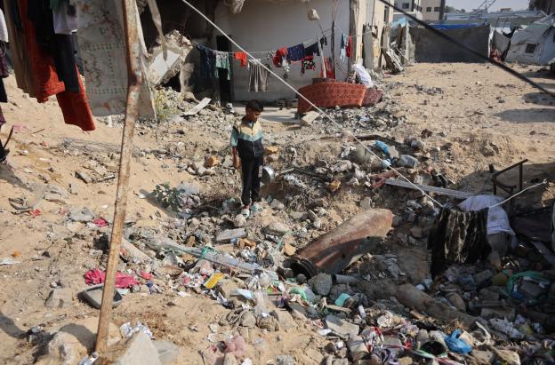 Un niño palestino observa un misil sin detonar en el barrio de Al-Rimal, en la ciudad de Gaza.