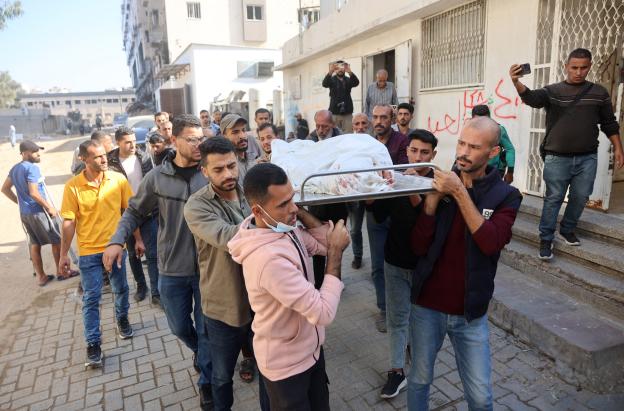 Los dolientes transportan el cadáver durante el funeral de un palestino que, según los médicos, murió el día anterior en un ataque militar israelí, desde el hospital Al-Shifa, en la ciudad de Gaza.