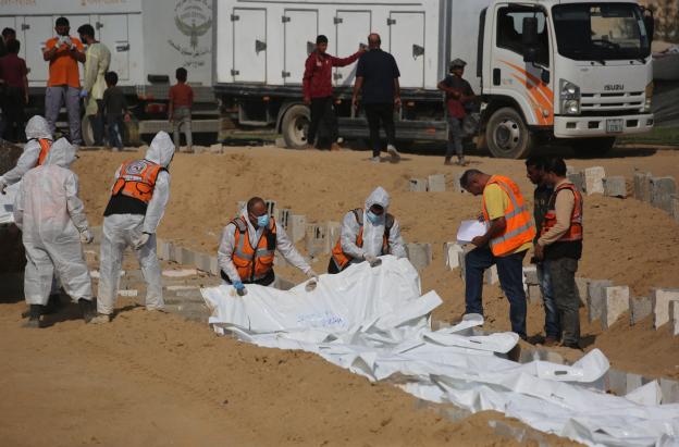 Trabajadores sanitarios y civiles se preparan para enterrar a palestinos en un cementerio de Jan Yunis, en el sur de la Franja de Gaza.