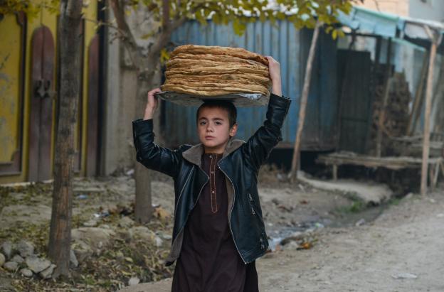Un niño en Afganistán lleva panes por una calle del distrito de Fayzabad, en la provincia de Badakhshan.