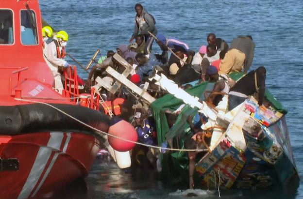 Esta imagen, tomada de un vídeo difundido por Televisión Canaria, muestra cómo una embarcación abarrotada de migrantes vuelca mientras sus ocupantes desembarcaban en el puerto de La Restinga, en la isla de El Hierro, Islas Canarias, España.
