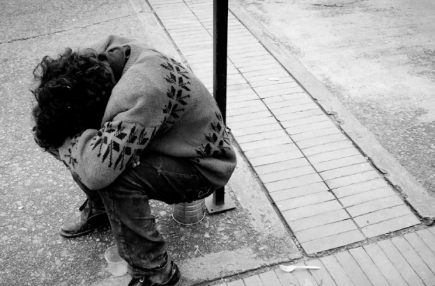 habitante de calle sentado y agachado