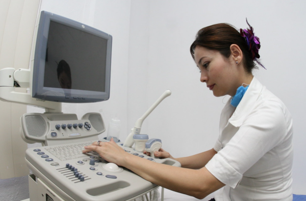 persona del sector salud operando una máquina de ecografías
