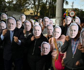 Personas con máscaras de Álvaro Uribe.