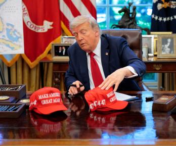 El presidente Donald Trump acomoda sus gorritas con el lema "Make America Great Again"