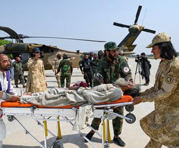 Voluntarios afganos y personal de seguridad talibán transportan a una víctima del terremoto evacuada por un helicóptero militar desde el distrito de Nurgal, en la provincia de Kunar, tras su llegada a Jalalabad para recibir asistencia médica.