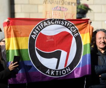 Contramanifestantes sostienen una bandera del partido antifascista Aktion en Barcelona el 12 de enero de 2020 durante una concentración de simpatizantes del partido español de extrema derecha VOX para protestar contra el nuevo gobierno de coalición del presidente del Gobierno español.