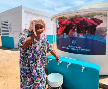 Mujer de la comunidad de Manaure utilizando el sistema de agua potable entregado por el Ministerio de Vivienda