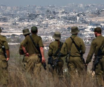Soldados del ejército israelí observan los edificios destruidos en la Franja de Gaza mientras se encuentran en la frontera con el territorio palestino.