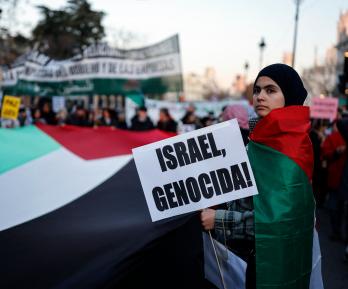 Una mujer sostiene un cartel con el lema «¡Israel, genocidio!» durante una manifestación en apoyo al pueblo palestino y para exigir el fin de la guerra en Gaza, celebrada en Madrid.