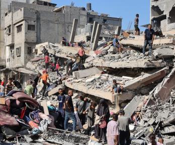 Palestinos inspeccionan un edificio destruido tras el bombardeo nocturno del ejército israelí sobre el campo de refugiados palestinos de Al-Shati, al oeste de la ciudad de Gaza.