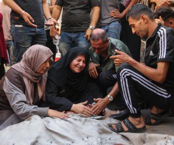Los palestinos lloran junto al cadáver de un familiar asesinado en los ataques israelíes contra la ciudad de Gaza al amanecer, en el hospital Al-Shifa. 