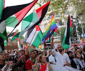 Manifestantes hacen gestos y ondean banderas palestinas durante una concentración convocada por la «Comunitat Palestina de Catalunya» (Comunidad Palestina de Cataluña) en solidaridad con los palestinos, frente al edificio «Casa Milà» del arquitecto español Antonio Gaudí, conocido popularmente como «La Pedrera», en Barcelona.