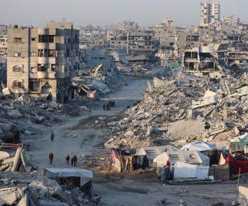 Palestinos caminan entre los escombros de edificios destruidos en el barrio de Sheikh Radwan, en la ciudad de Gaza.