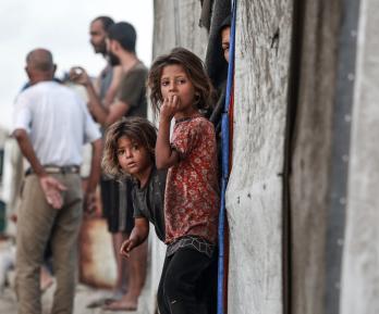 Niñas palestinas desplazadas junto a la entrada de una tienda utilizada como refugio temporal en Deir el-Balah, en la Franja de Gaza central.