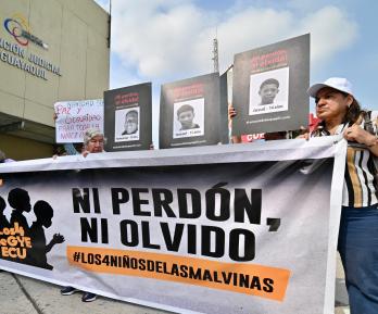 Familiares y miembros de organizaciones de derechos humanos sostienen fotografías y una pancarta con el lema «Ni perdón ni olvido» frente a un tribunal de Guayaquil, Ecuador, tras la condena de los 11 militares por desaparición forzada. 