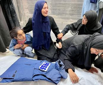 Familiares junto al cadáver del periodista Ahmed Mansur en el Complejo Médico Nasser, en Jan Yunis, al sur de la Franja de Gaza. Uno de los periodistas asesinados por Israel.